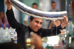 Smiling man pouring martinis